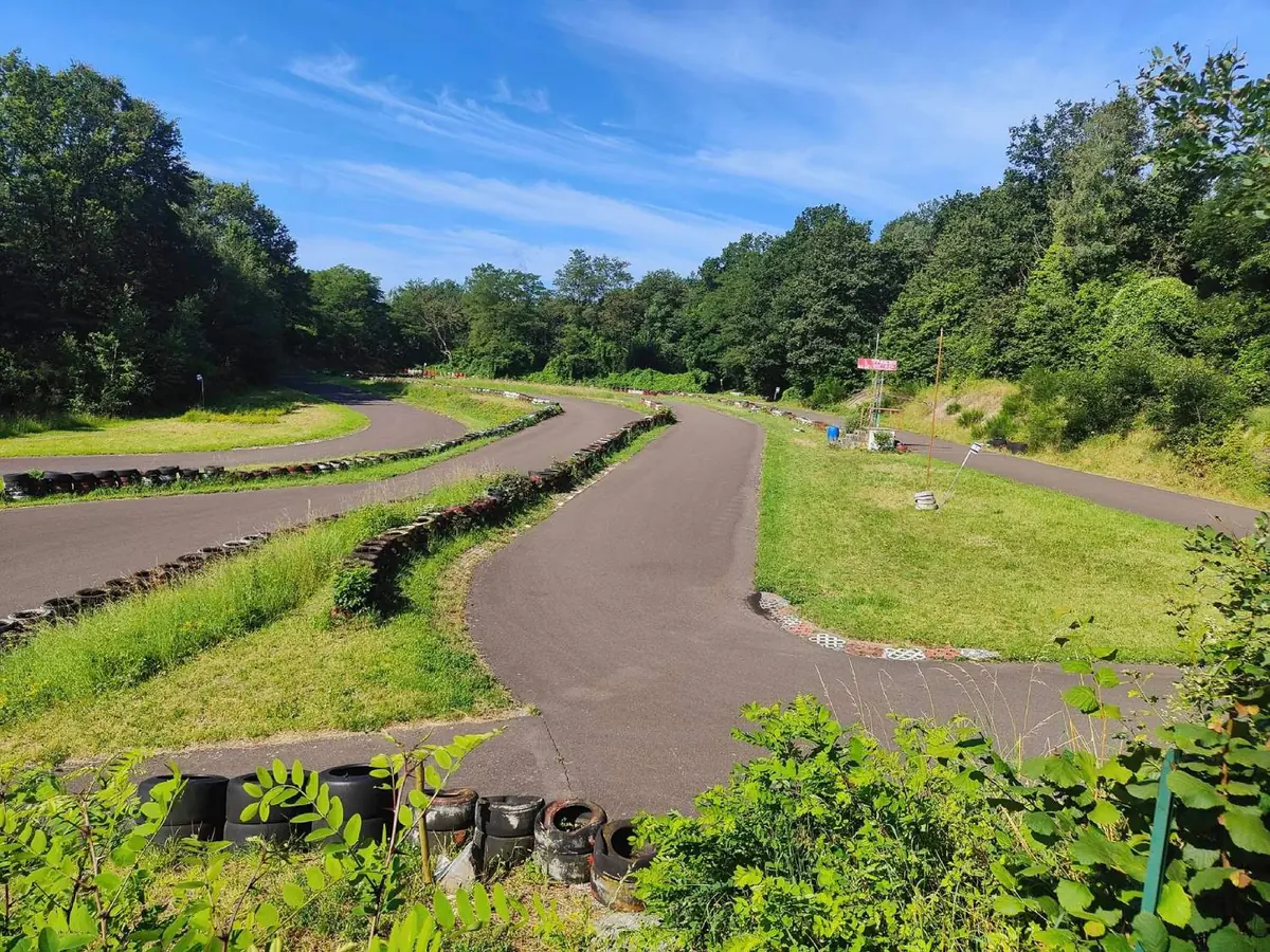 Vue du circuit extérieur de Cobra Karting Amay, entouré de verdure.